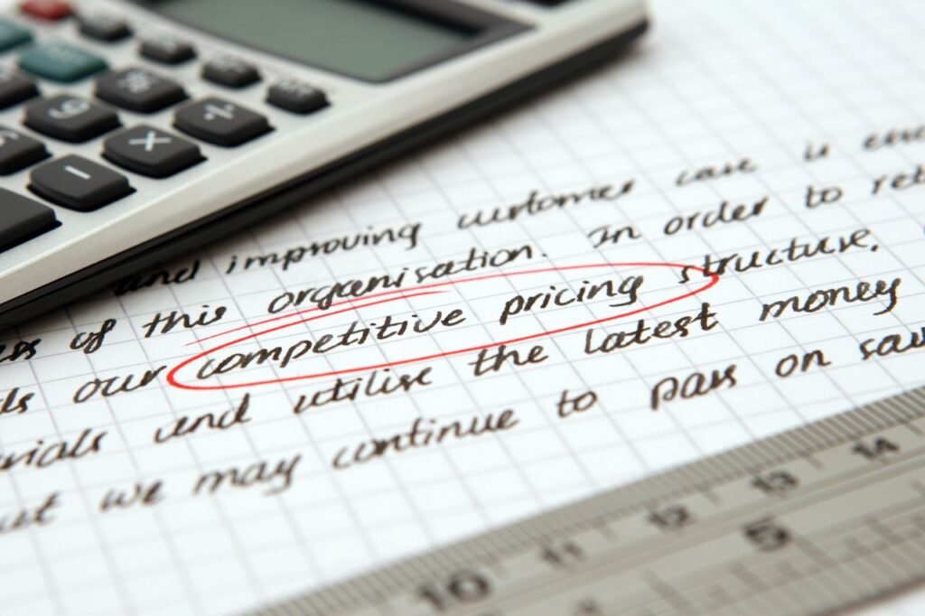 Home Focused image of handwritten business notes with calculator emphasizing pricing strategy.
