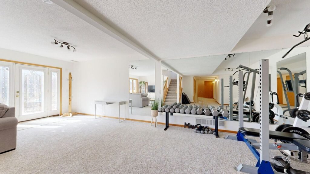 Home Bright home gym setup with weights, mirrors, and modern decor.