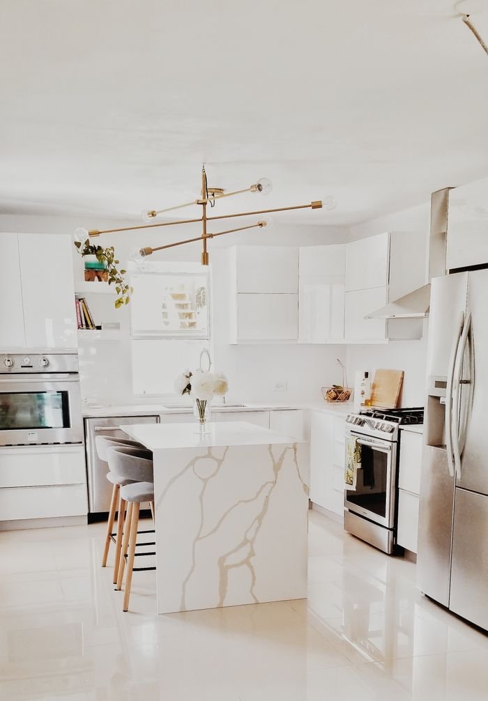 Projects A bright, modern kitchen featuring white cabinetry, stainless steel appliances, and minimalist decor.