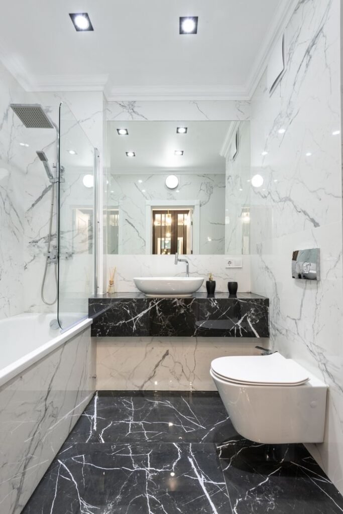 Projects Luxurious bathroom featuring marble walls and floor with modern fixtures and minimalist design.