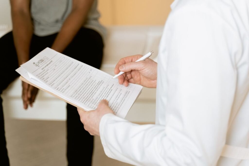 Home Healthcare professional reviews medical form during patient consultation in a clinic setting.